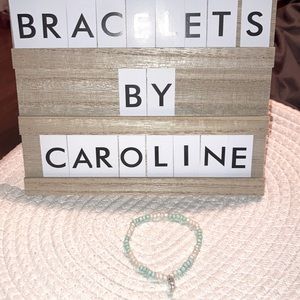 One homemade blue and white bracelet with a silver anchor charm